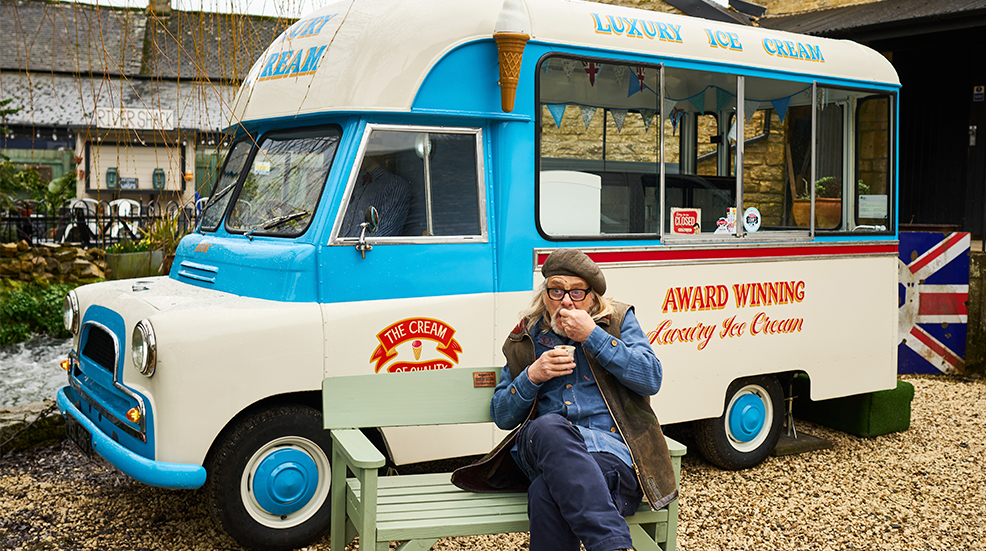 Henry Cole sat in front of Bertie the ice cream van, tucking into an ice cream